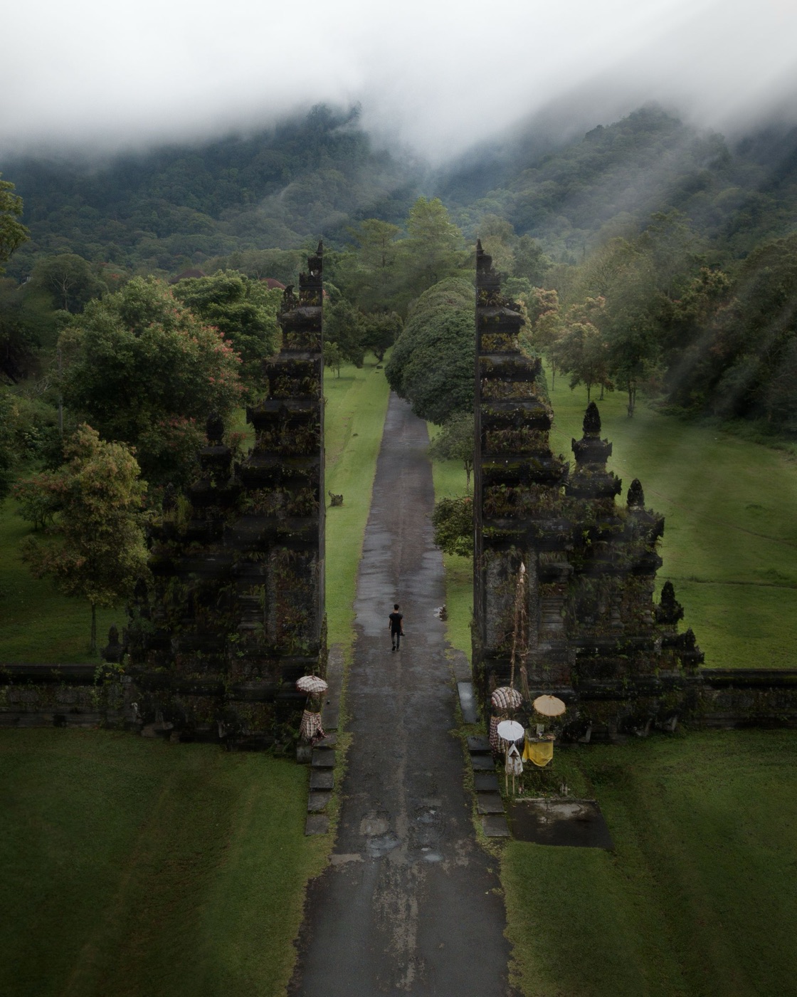 The iconic Handara Gate framed by tropical foliage and misty mountains in Bali.